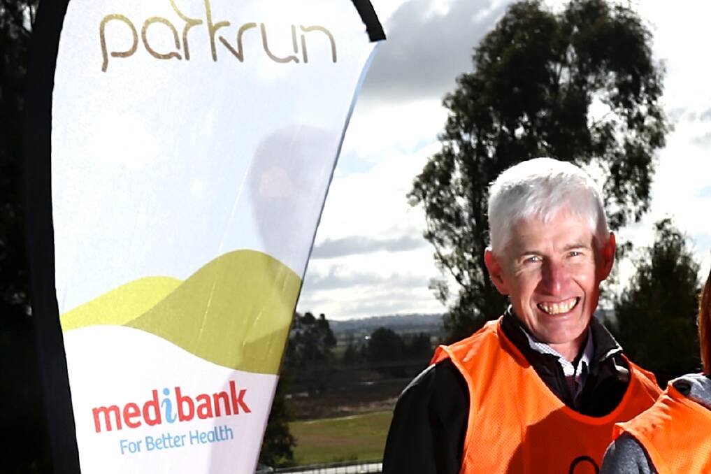 Stephen Jackson next to a banner for parkrun, the event he helped bring to Bathurst. Picture by Phil Blatch