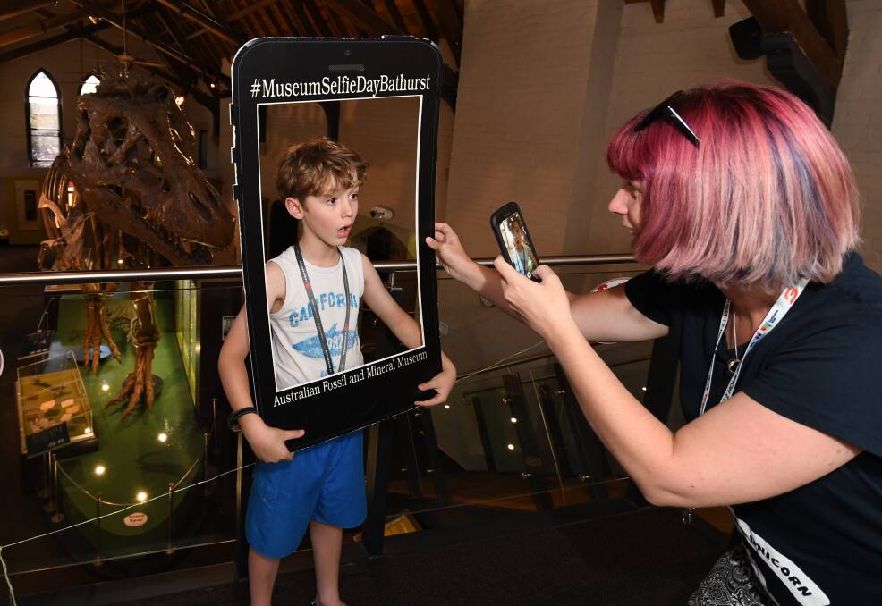 STRIKE A POSE: Ben Irwin, 9, embraced Museum Selfie Day by posing with a T-Rex while his mother, Lorraine Heness, took a quick photo. Photo: CHRIS SEABROOK 011718cselfie1