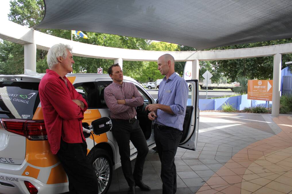 GREEN: Councillors John Fry and Jess Jennings talking about council's plug-in hybrid vehicle last year with environmental officer Joel Little.
