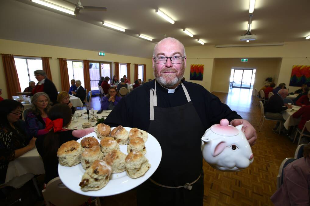 TEA TIME: Rector Tim Fogo helped serve the guests during the Holy Trinity Church's high tea on Saturday. Photo: PHIL BLATCH 071418pbtea9