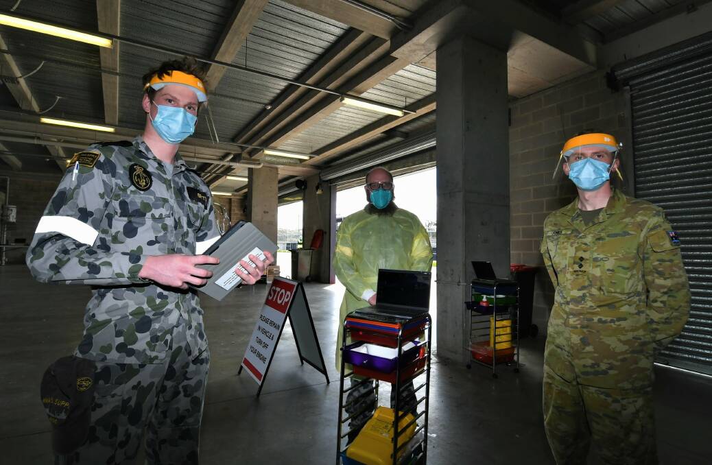 DELIVERING THE JAB: Australian Defence Force personnel, able seaman Max Betts and Nathan Rumph, and lieutenant Euan Jones, at the drive-in vaccination facility at Mount Panorama. Photo: CHRIS SEABROOK 100521cvax1
