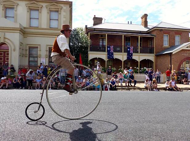 A TASTE OF OLD: A penny-farthing being ridden down the street at the Carcoar Village Fair. Photo: NICHOLAS LEE