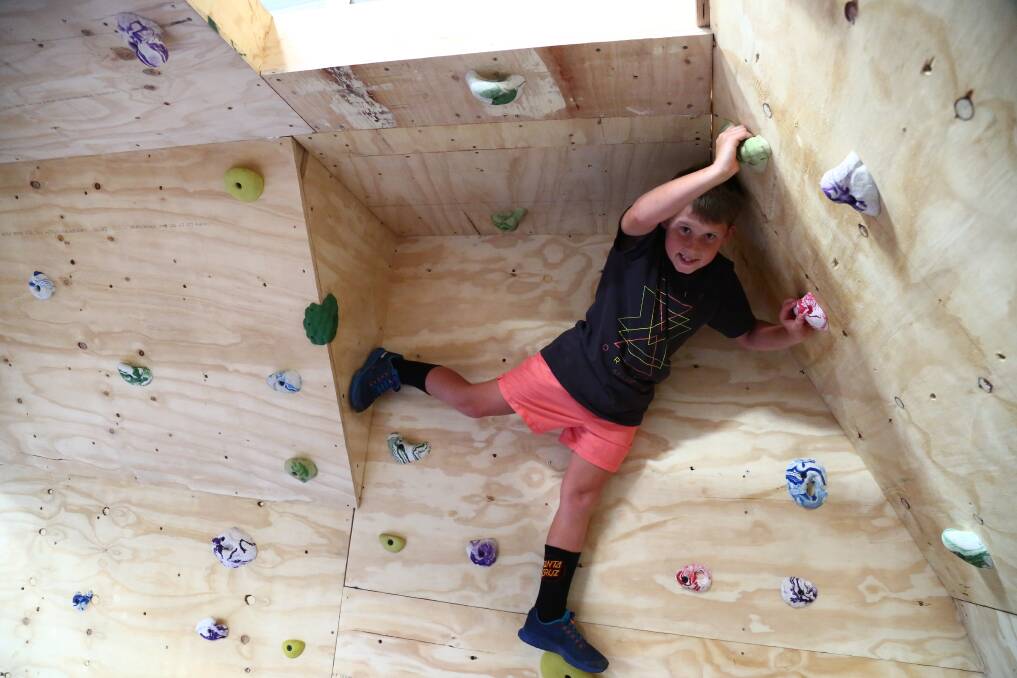 JUST HANGING AROUND: Will Pheils, who was in the junior Ninja Warrior competition, posed for a photo after scaling the wall in the PCYC's new space. Photo: PHIL BLATCH 041818pbninja1