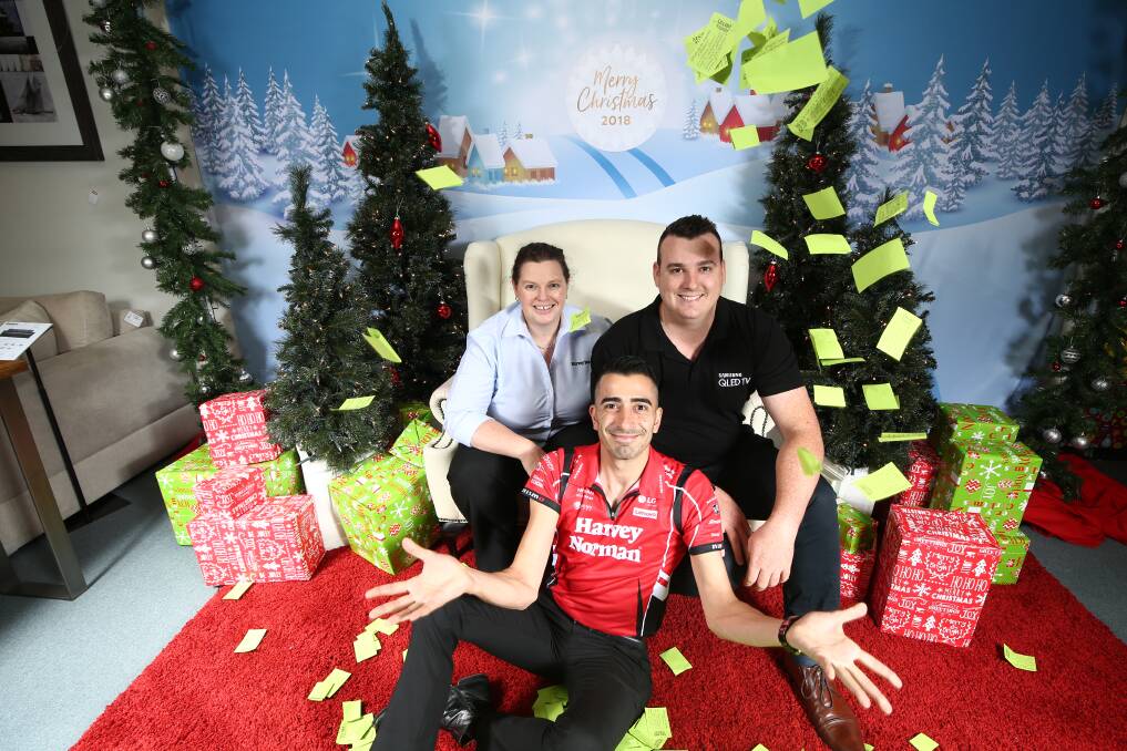 FESTIVE: Bathurst Harvey Norman franchisees Sam Sultan, Abbie Miller and Todd Bray being showered in Festive Frenzy tickets. Photo: PHIL BLATCH 