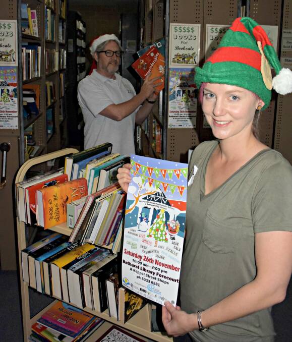 VARIETY: Bathurst Library staff members Natalie Conn (front) and Shane Summerton with some of the books that will be available at the Christmas on Keppel community fair on Saturday. Photo: RACHEL FERRETT 112516rfxmas