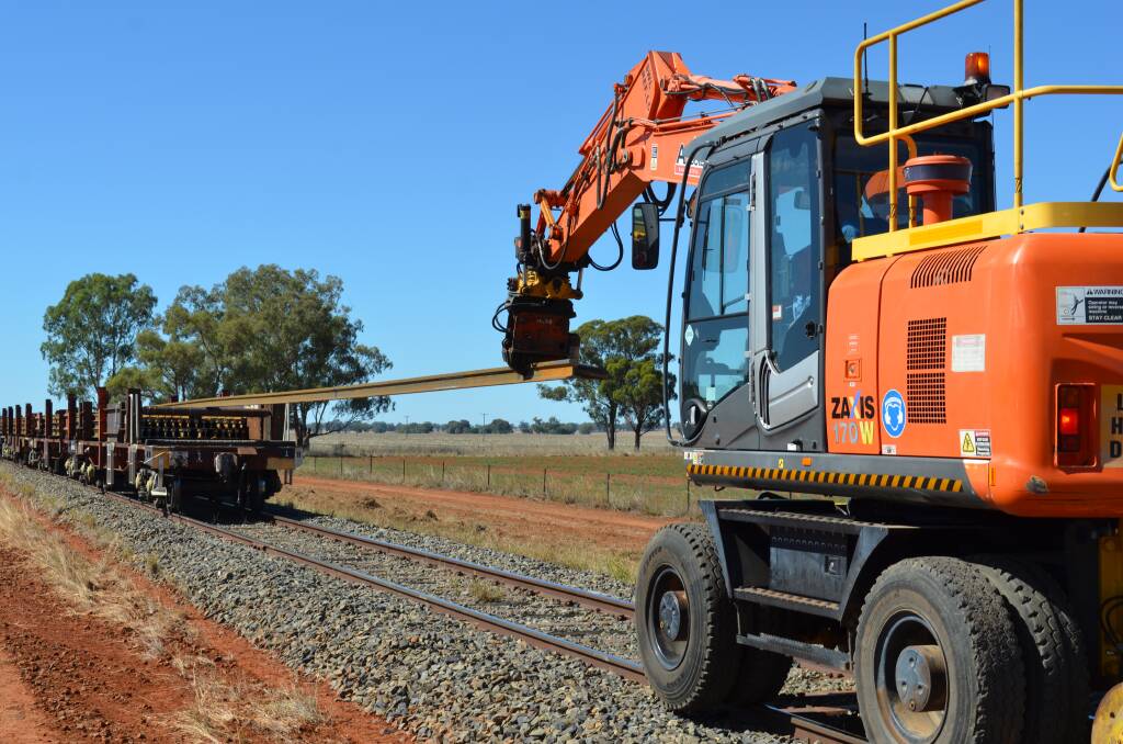 FOUNDATIONS: Australian Rail Track Corporation employees remove 165-metre lengths of steel that will form the Inland Rail between Parkes and Narromine.