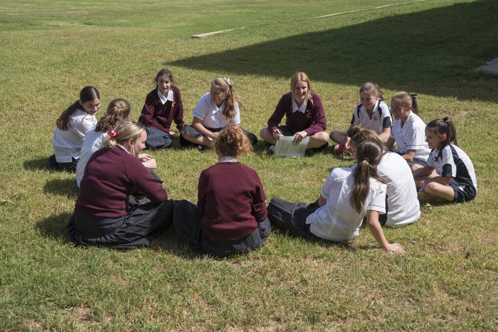 Helping Hands: As part of their well-bring program, Year 11 girls help support their fellow students in Year 7 through Peer Leadership. Photo: Supplied.