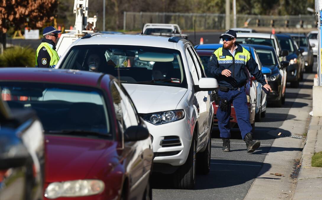 Police at a vehicle checkpoint on the NSW-Victorian border.