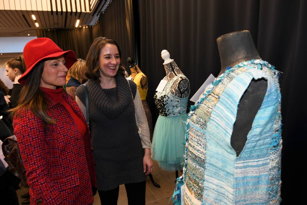 CREATIVE DESIGNS: Anna Dove and Alyssa Potter admire a design by 'Gypsy Weaver Cathy Tobin. It is made using a free weaving style called SAORI. Picture: Lachlan Bence 