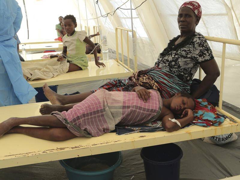 A mother sits by her daughter after she was diagnosed with cholera at a Mozambique treatment centre.