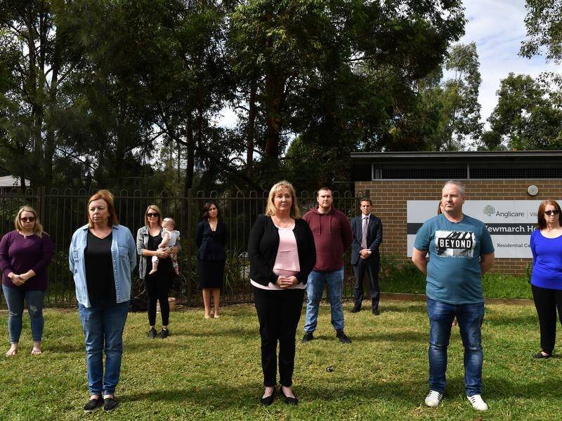 Family members of residents at Anglicare's Newmarch House stand outside the aged care home.