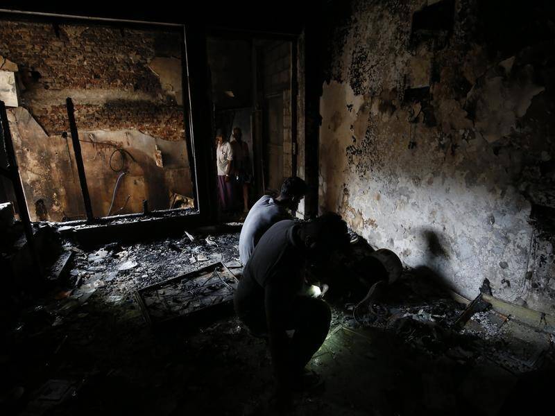Sri Lankan Muslims inspect their fire-gutted property in Kandy.