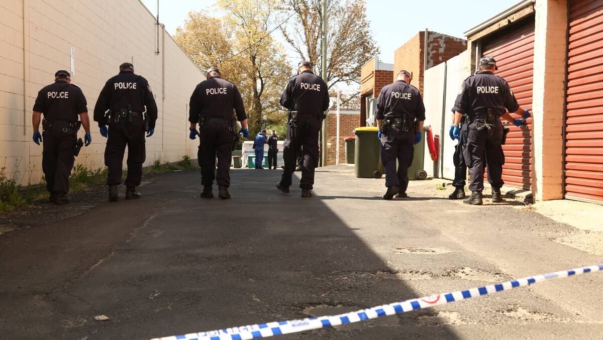 SEARCH FOR CLUES: Police conduct a line search in Mugridge Lane yesterday after a woman was assaulted on Thursday night. Police are appealing for anyone with information about the assault to come forward. Photo: PHIL BLATCH 	100915pblane11