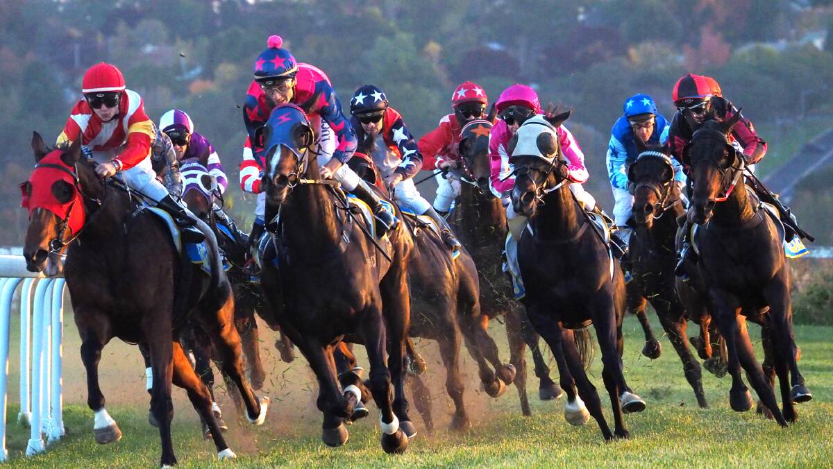 COMING THROUGH: Black Friday (navy cap with white stars, fifth from right) with jockey Michael Travers looks for the gap in the Soldier’s Saddle on ANZAC Day. Photo: ZENIO LAPKA 	042514zsaddle1a