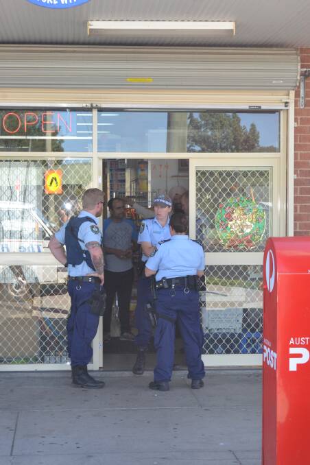 CAUGHT ON CAMERA: Police at the Lucky 7 convenience store following an alleged armed robbery on December 30. Photo: NADINE MORTON	 123015nmrobbery4