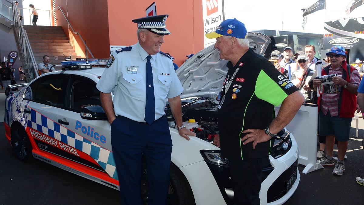 FAST AND FURIOUS: NSW Police Assistant Commissioner and commander of traffic and highway patrol John Hartley with V8 hall of famer Dick Johnson talking speed and the newest police force showpiece. Photo: PHILL MURRAY 101014phiway
