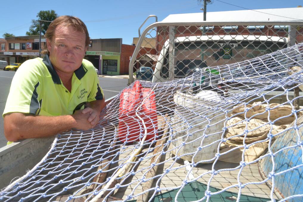 TIED DOWN: Bathurst landscaper David Varman now uses a cargo net to secure items in the rear of his work ute to avoid a hefty fine. Photo: BRIAN WOOD 123114bwnet