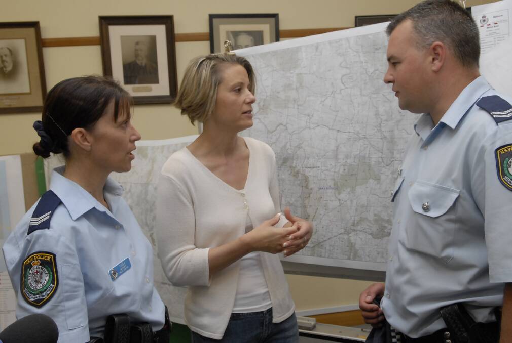 FLASHBACK: Former Premier Kristina Keneally (centre) met Senior Constables Caroline Tomek and Troy Simmons in the days after the 2009 bushfire. Photo: PHILL MURRAY 121009pfire8