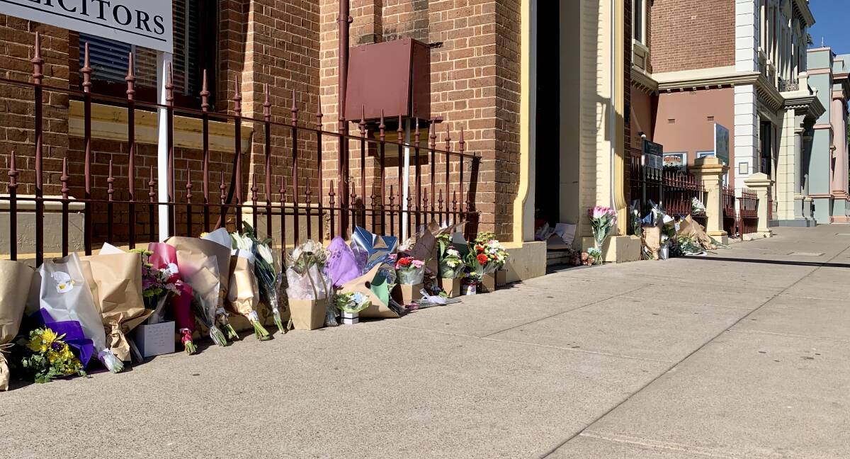 A row of flowers laid outside a building in Mudgee's CBD.