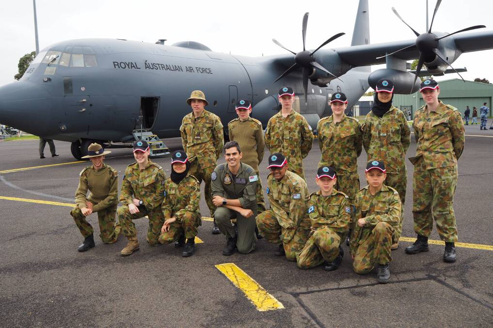 FLY HIGH: Royal Australian Air Force No. 37 Squadron training flight commander Adrian Willey with cadets from Bathurst, Orange and Glenbrook pose in front of a C-130J Hercules aircraft on Saturday. Photo: SAM BOLT