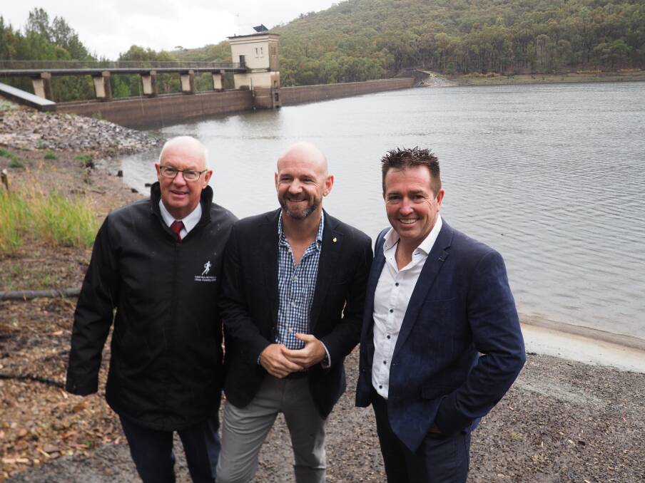 BRAVING THE RAIN: Mayor Graeme Hanger, State Minister for Regional Water Niall Blair and Member for Bathurst Paul Toole announce new upgrades to the Winburndale Dam. Photo: BRIAN WOOD
