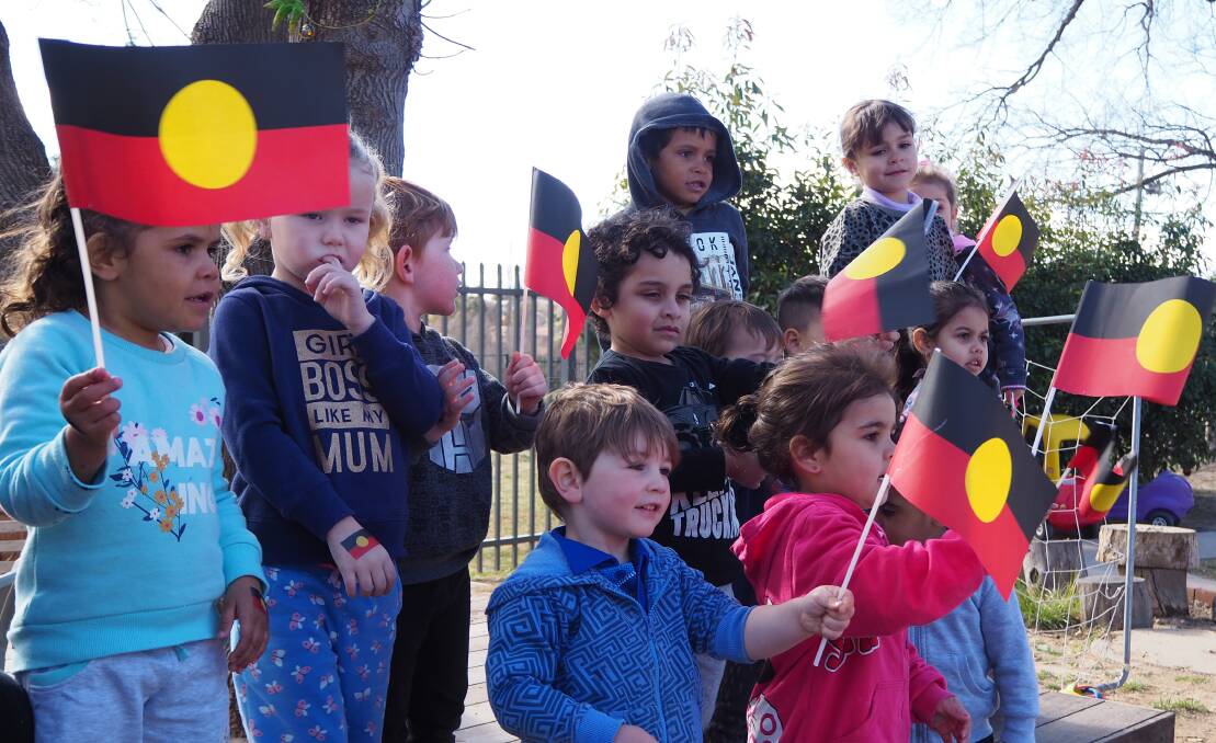 WAVING THE FLAG: Towri MACS Centre children take part in an acknowledgement of country. Photo: SAM BOLT
