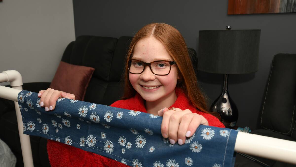INGENIOUS IDEA: Alannah Smith, 14, with one of her hand made trolley handle covers. Photo: CHRIS SEABROOK 081820covers