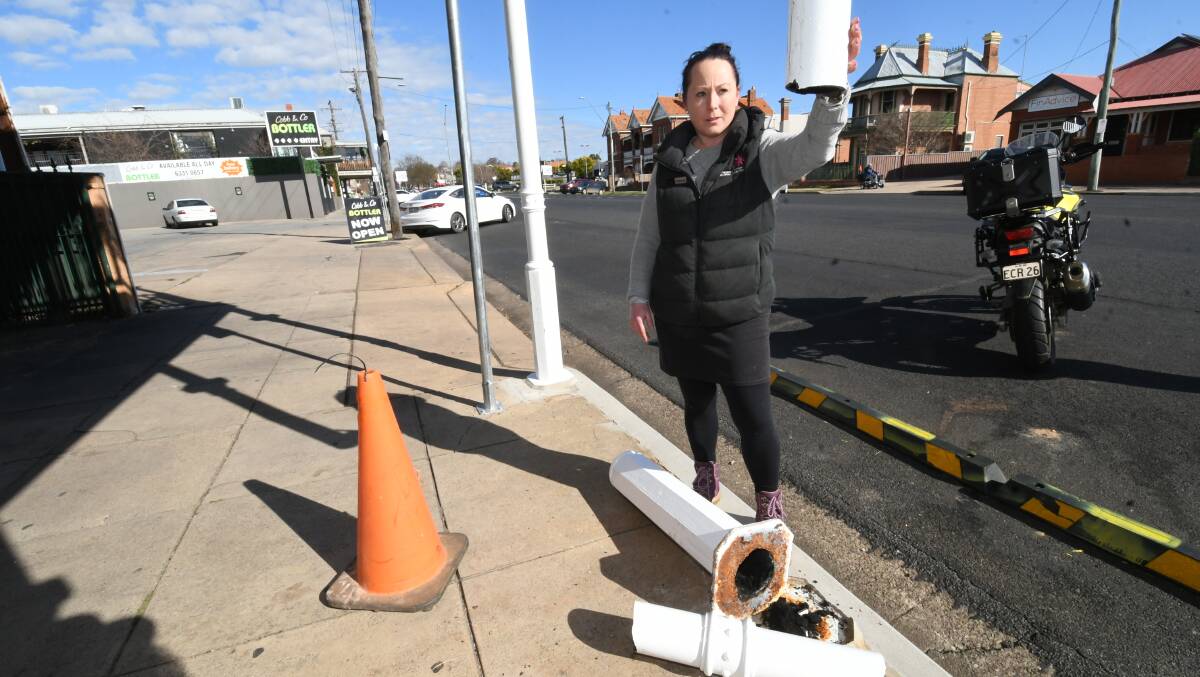 HISTORIC POST BROKEN: Business owner Vanessa Pringle with the damaged structural support post outside her premises on Wednesday. Photo: CHRIS SEABROOK 070120cdamage1