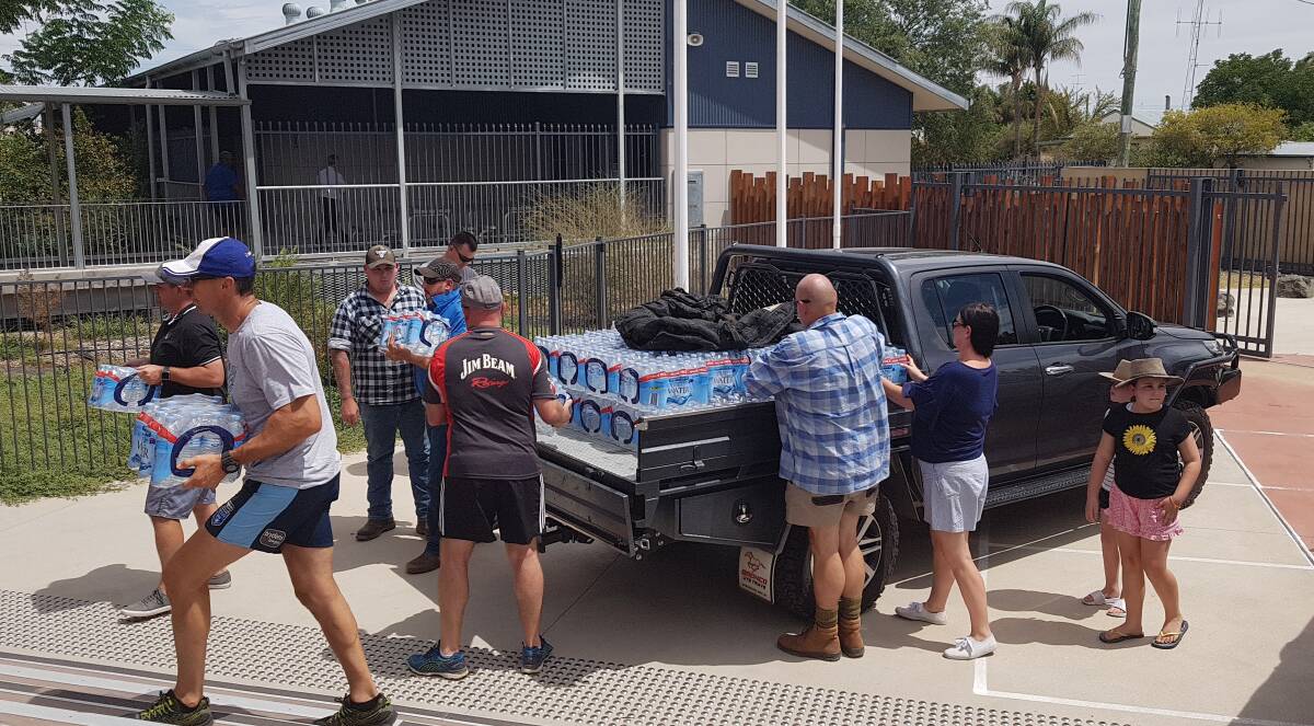 HELPING HAND: Officers from Bathurst, Kirkconnell, Macquarie and Lithgow Correctional Centres delivering packs of water to Walgett Community College. Photo: SUPPLIED