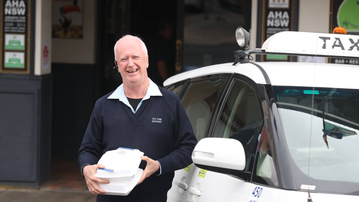 TUCKER: Bathurst Taxis' Paul Shanahan outside Jack Duggans Irish Pub, who offer food delivery through the Taxi Tucker service. Photo: PHIL BLATCH