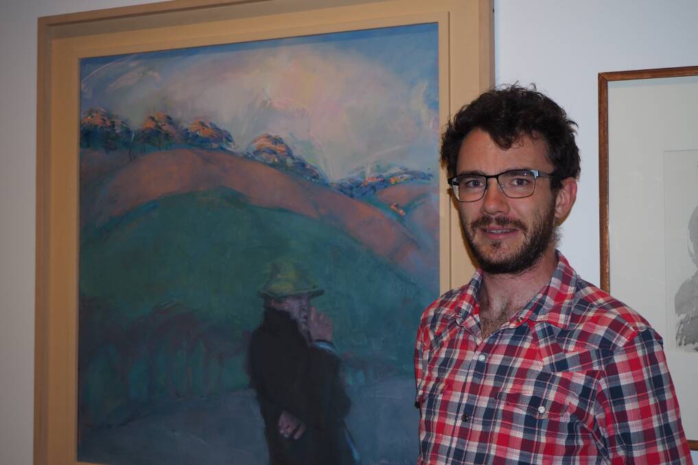 COMMAND OF COLOUR: Bathurst Regional Art Gallery acting audience engagement officer Julian Woods with the David Brian Wilson artwork 'Man at Evening.'