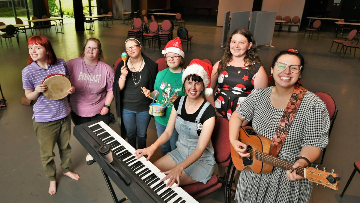 JOLLY SING-A-LONG: Abby Smith and Sophie Jones [right] rehearsing with Compareo participants at the Bathurst Memorial Entertainment Centre. Photo: CHRIS SEABROOK 121421compareo