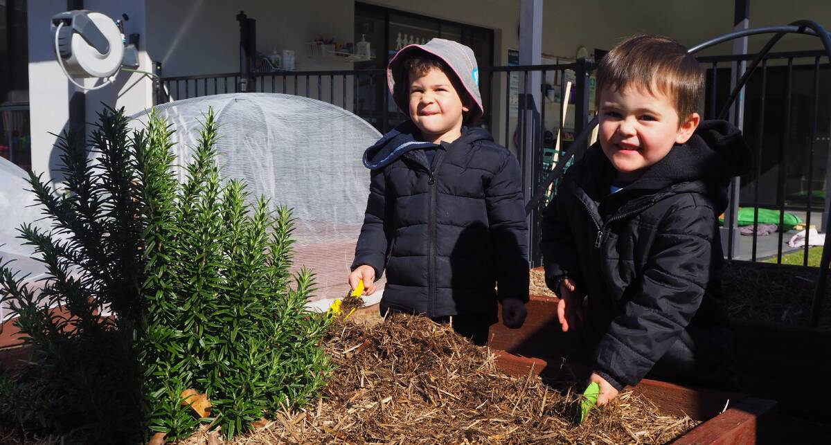PLANTING KNOWLEDGE: Simieon Latu and Oscar Stevens in the garden at Kelso's Goodstart Early Learning Centre. Photo: SAM BOLT