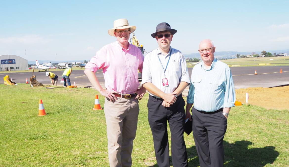 FLYING: Federal Member for Calare Andrew Gee, Bathurst Regional Council director of engineering services Darren Sturgiss and mayor Graeme Hanger oversee construction of a new parallel taxiway at Bathurst Airport.