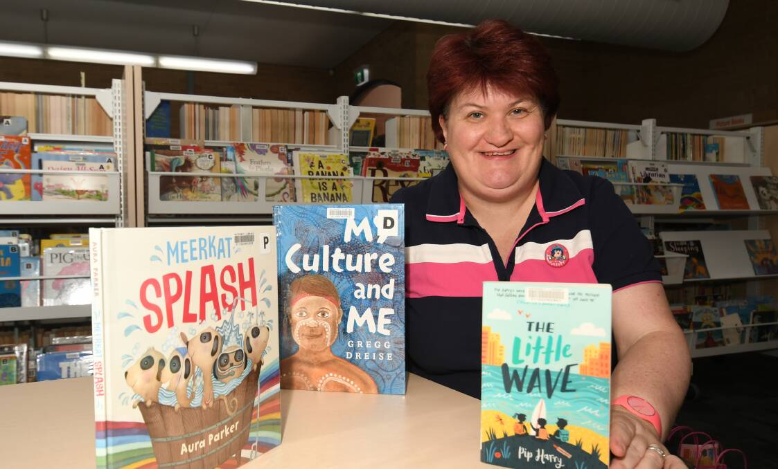 DEVELOPMENTAL READING: Speech pathologist Kathy Rowan with some of the approved books. Photo: CHRIS SEABROOK