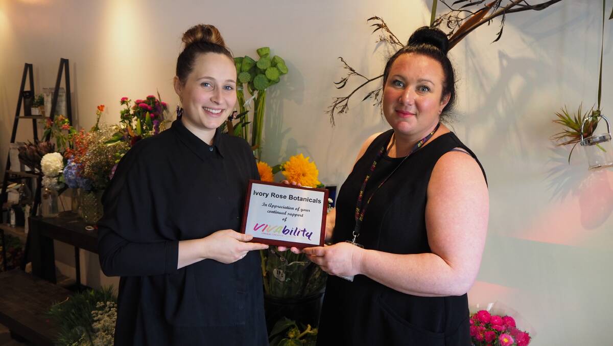 FLORAL FANTASTIC: Vivability community access manager Ruth Thurtell presenting a plaque of appreciation to Ivory Rose Botanicals owner Maddy Veitch. Photo: SAM BOLT 122118sbviva2