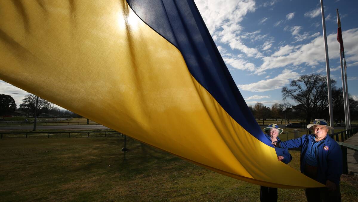Judy and Dom Chircop with the Ukrainian flag at the Evans Bridge flagpoles. Picture: Phil Blatch