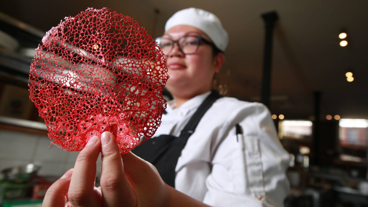 GASTRONOMIC: Cobblestone Lane sous chef Elaine Mante with 'coral' garnish, created through a chemical reaction of water, oil, flour and red food colouring. Photo: PHIL BLATCH