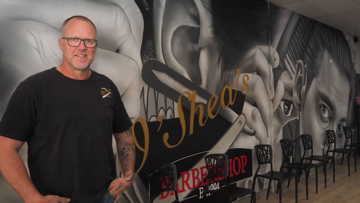 O'Shea's Barber Shop owner John O'Shea with the shop's new mural, painted by emerging street artist and former Bathurst local, Callum Hotham. Picture: Sam Bolt
