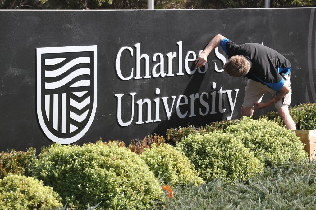 NEW LOOK: Workers installing the new logo sign at Charles Sturt University's entrance in Bathurst on Wednesday morning. Photo: PHIL BLATCH 050119pbcsu2