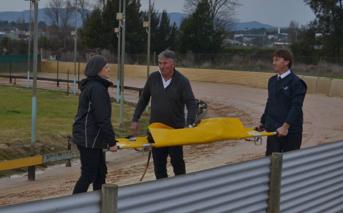 CARRIED OFF: Race favourite, Ef Ay Zarr, was stretchered off the track after a tumble left her injured. Photo: NADINE MORTON 080116nmdogs3