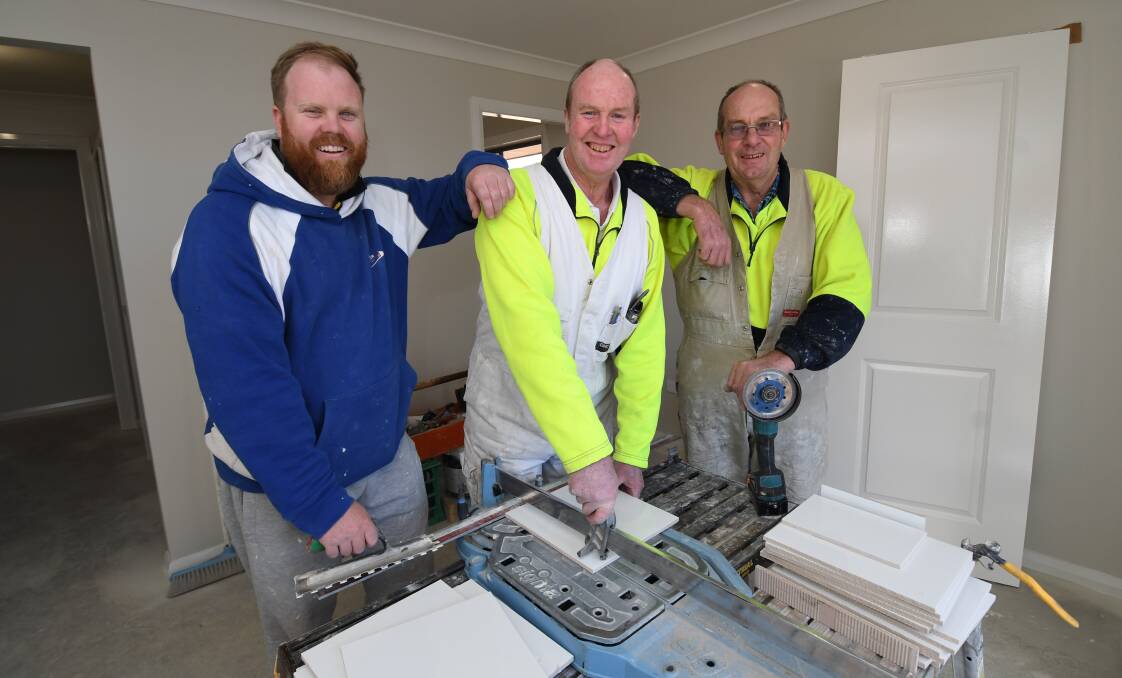 ON THE JOB: Adam McKay with his father Ian and uncle Ralph have 100 years of tiling experience between them. Photo: CHRIS SEABROOK 060418ctilers1