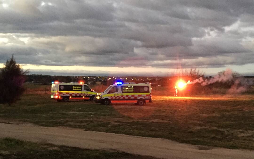 IN HOSPITAL: Paramedics let off a flare to help guide the NSW Ambulance helicopter in to land off Hereford Street. Photo: NADINE MORTON 061417nmmva12
