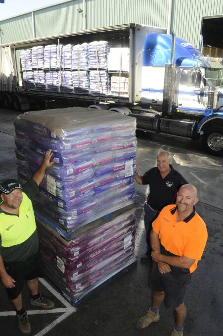 BIG HAUL: Dawson's Distributions' Ian Crook, Mars Petcare's John Lennon and Cranston's Transport's Brett Cranston with some of the pet food load bound for the firezone. Photo: CHRIS SEABROOK 022117cmars1