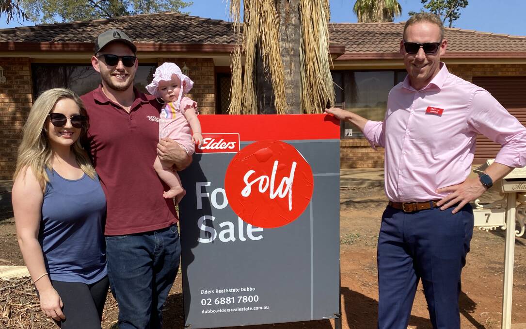 MILESTONE: Dubbo couple Taylar Osborne and Jack Browne and seven-month-old daughter Hollie Browne celebrate the purchase of their first home with real estate agent Adam Wells. Photo: SUPPLIED