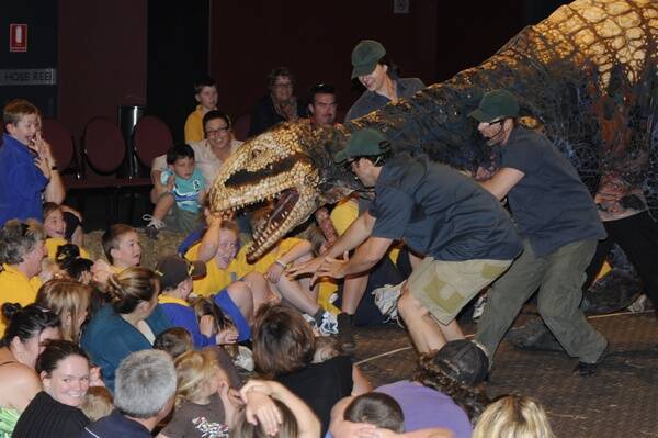 WATCH OUT: Audience members ducked away as chief dinosaur wrangler Michael Cullen tried to stop a dwarf allosaur charging towards the crowd during a performance at Bathurst Memorial Entertainment Centre yesterday. Photo: CHRIS SEABROOK 110810cdino8
