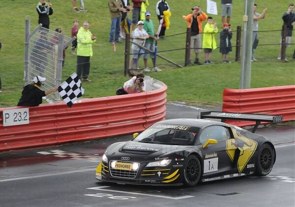 GOING THE DISTANCE: Darryl O’Young greets the chequered flag after he and his Phoenix Racing team-mates Christer Joens and Christopher Mies yesterday covered 270 laps (1677kilometres) in their Audi R8. Photo: CHRIS SEABROOK 022612c12hrfin1