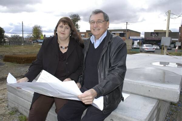 BACKING BATHURST: Local developer Bruce Bolam and daughter Megan Bolam-Williams study plans for the proposed Centrelink development next to the Western Advocate