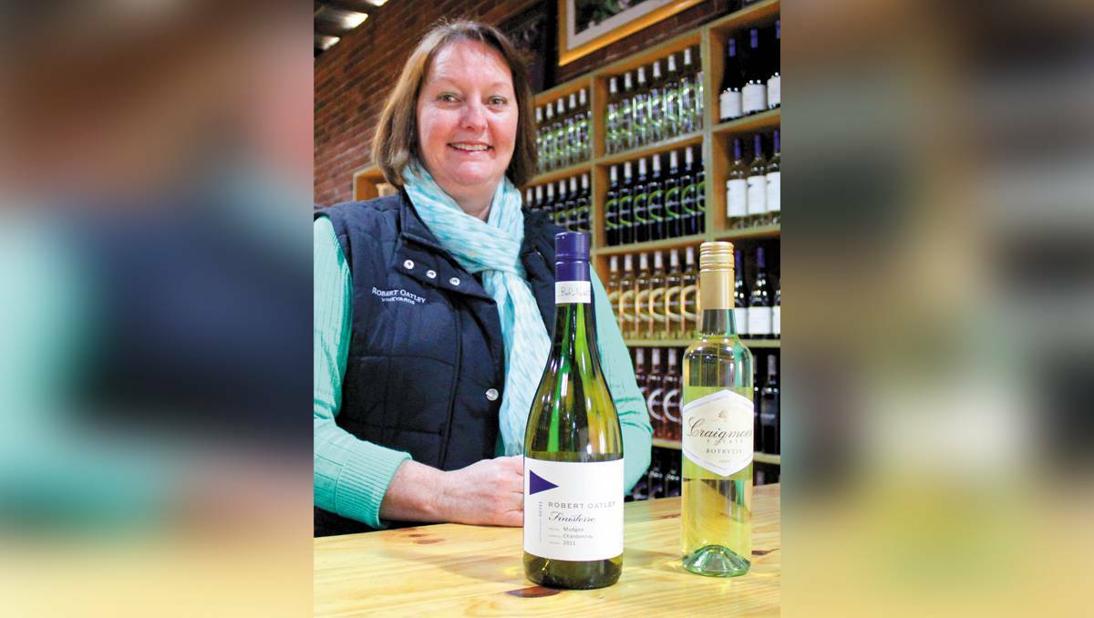 MUDGEE: Robert Oatley Vineyards’ Amanda Lyons with two high-rated wines featuring in James Halliday’s 2014 Australian Wine Companion. She is pictured with a 2011 Robert Oatley Finisterre Mudgee Chardonnay and a 2009 Craigmoor Estate Botrytis that helped the wine company reach five-star status. PHOTO BY DARREN SNYDER