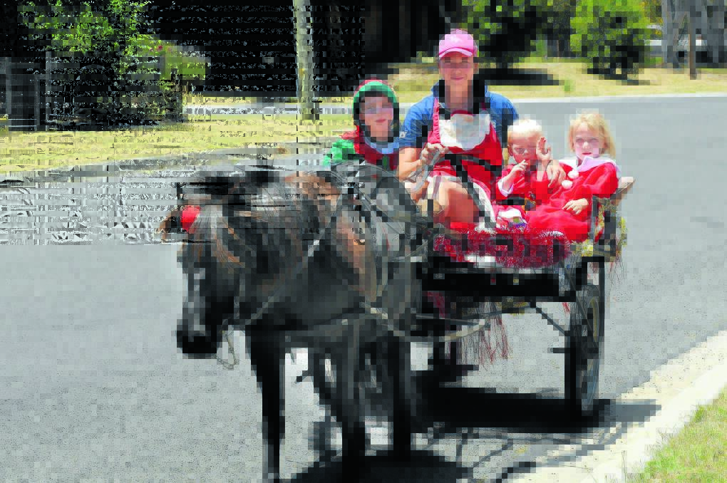 HORSE AND SULKY: Mandy Scott and her children Hamish, 6, Logan, 2, and Evie, 4, hit the streets yesterday to bring some Christmas cheer to their Eglinton neighbours. Photo: PHILL MURRAY	 122112psanta2